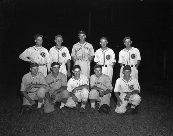 Group portrait of the Hellenbrand family softball team that will play a special exhibition game against the Madison Gardner Bakery team. The Hellenbrand team is sponsored by the Middleton Cardinals baseball team.  Pictured left to right, first row: LaVerne Hellenbrand, Ben Hellenbrand, Carl Hellenbrand, Norbert Buecher (a cousin), and Bob Hellenbrand. Back row: Roman Hellenbrand, Louis Hellenbrand, Albert Hellenbrand, Herb Hellenbrand, and Syl Hellenbrand. Not pictured is a Hellenbrand cousin, Gene Kaltenberg, a member of the Gardner Bakery team, who will be "loaned" to the Hellenbrand lineup for the game.