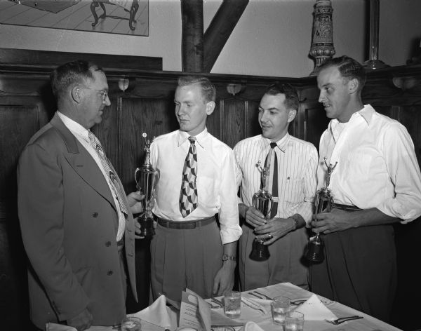 Three drivers for the Severson Milk Company, Albion, receive awards for safe driving at their annual supper held at the Heidelberg Hofbrau restaurant in Madison. From left: Arthur Severson, company president; his son, LaVerne, Albion, who drove 266,040 miles in three years; Wesley Ciebell, Edgerton, 373,560 miles in four years one month; and Marvin Amundson, Edgerton, who drove 325,640 miles in three years eleven months. The men received trophies and an extra week of paid vacation for driving a minimum of 250,000 miles without an accident involving damage of more than $100.