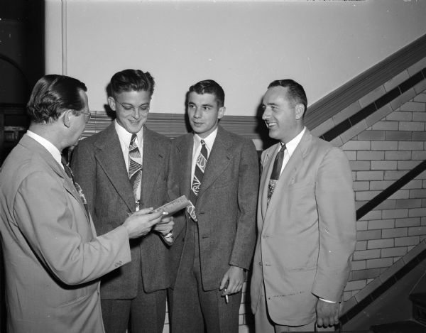 Two World War II veterans from Berwyn, Illinois, released on bail pending a new hearing, are with their lawyers. The two young men were convicted and imprisoned for robbery and assault, but are being granted a new trial. From left: Attorney Micheal R. Kazunas, Chicago, a friend of both young men's parents; Robert D. Tomsa and Daniel John Cizek, both twenty-three year old veterans; and Attorney Willaim J. Coyne, Madison.
