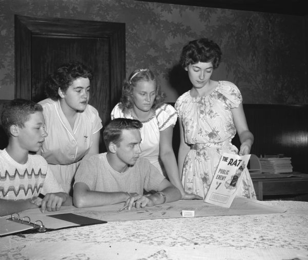 Mary Traino (left), Joyce McConley, and Ruth Steinle gather with two boys while discussing the Junior Red Cross campaign against "The Rat-Public Enemy No. 1."