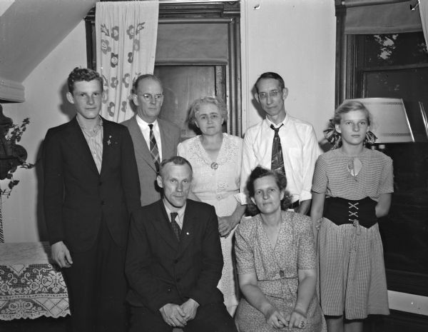 The Matiss Briedis family, from Latvia, with some of the Madison men and women who have found them a new home in Madison. Seated are Matiss, 42, former Latvian army officer and now an electrician, and his wife Eleanor, 44, teacher and linguist. Standing, left to right, are their son, Uldis-Jekabs, 16; Dr. Alfred W. Swan, pastor of First Congregational Church, the sponsoring agency; Mrs. Moses Smith, member of the church's displaced persons committee, Kurt Brueckner, whose wife heads the committee and daughter Signe Kristine.