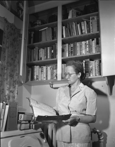 Alice Vinje posing with her collection of cookbooks at her 2800 Mason Street home.