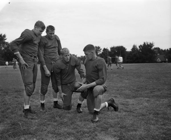 Four West High School football players during a practice. From left they are: Jack Mansfield, Jack Barry, John Wing, and Bob Bakke.