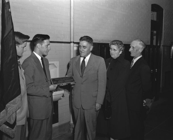 Dedication of a drinking fountain at Central High School as a memorial to Pfc. James Hammond, son of Howard and Regina Hammond, 114 North Bassett Street. Hammond, was a 1943 graduate of Central High School. He was killed during the Battle of the Bulge and was posthumously awarded the silver star. Pictured left to right: Don Noel, president of the student council; Tom Jafferis, president of the Class of 1943; Principal Leonard Waehler; and Regina and Howard Hammond.