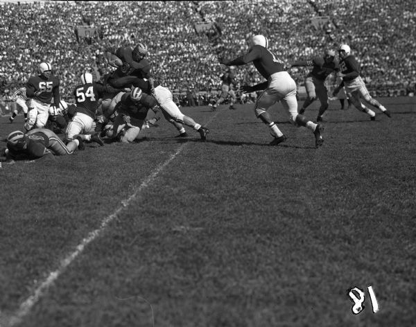University of Wisconsin vs. Marquette Football game. Norm Rohter, Marquette No. 31; Robert "Red" Wilson, Wisconsin No. 53; Joe Kelly, Wisconsin No. 54 and Bob Hester, Marquette No. 34