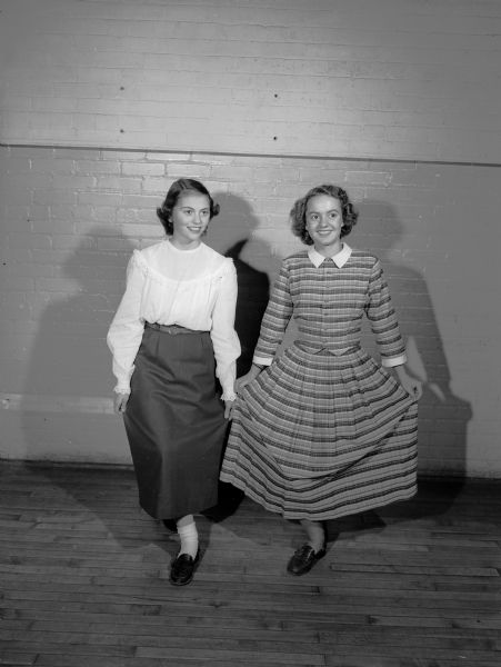 Two high school girls, Virginia Stamm (left), 3405 Crestwood Drive, and Jeanne Tierney, 2922 Lakeland Avenue, are shown practicing for their roles as "hoop skirt girls" in the JCC musical revue, "Then and Now".
