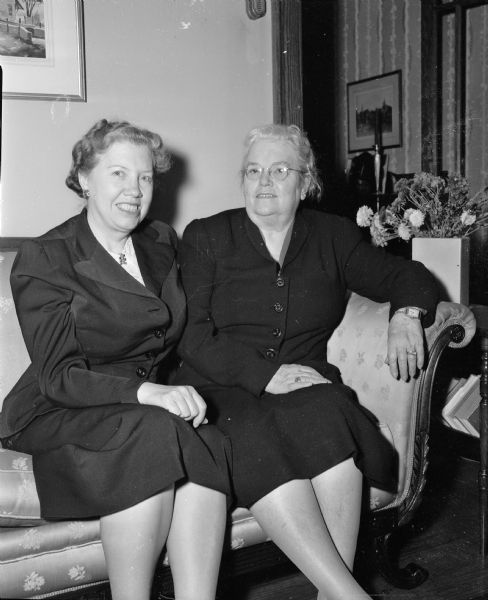 Nell V. Nichols, left, field editor for "Woman's Home Companion" magazine, and Mrs. Andrew (Bess) Hopkins, Shorewood, sitting side by side on a couch. Mrs. Nichols is an alumni of the University of Wisconsin.