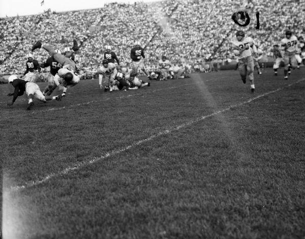 Action shot during the fourth quarter of the Wisconsin vs. California football game at Camp Randall Stadium, featuring Pete Schabarum, California, #32; and Wisconsin players, Ed Withers, #11; Gene Felker, #90; and Joe Kelly, #54.