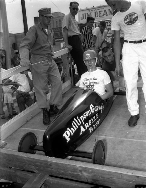 The car and driver that won the Madison Soap Box Derby in 1957 at the starting line. The car is called "Phillipson Garage" and the driver is Van Steiner of Argyle.