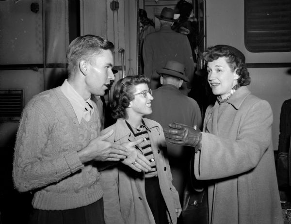 Rise Stevens arrives in Madison for a concert at the Wisconsin Union Theater. Greeting her at the train station are George Holcomb, Kankakee, Illinois, student concert manager and Barbara Connell, Waukesha, chairman of the Wisconsin Union concert committee.