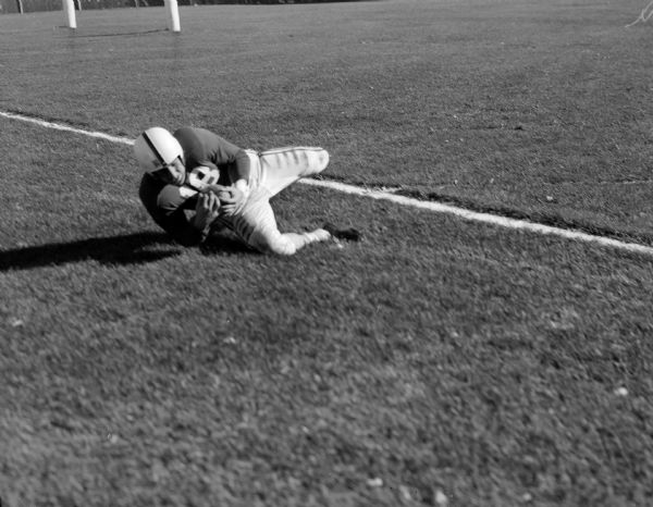 Wisconsin player Jerry Schaefer falls to the ground after catching a pass on the Navy two-yard line during the football game between the University of Wisconsin and the Navy Midshipmen in Camp Randall.