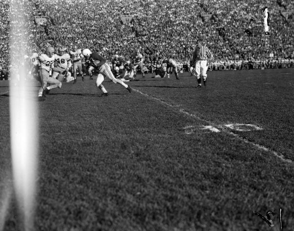 Wisconsin's Lisle Blackbourn (33) faces a wall of Navy defenders during the football game between the University of Wisconsin and the Navy Midshipmen in Camp Randall. The Navy players in the picture are Tony Bartuska (25), Art Sundby? (48), and Harrison Frasier (82).