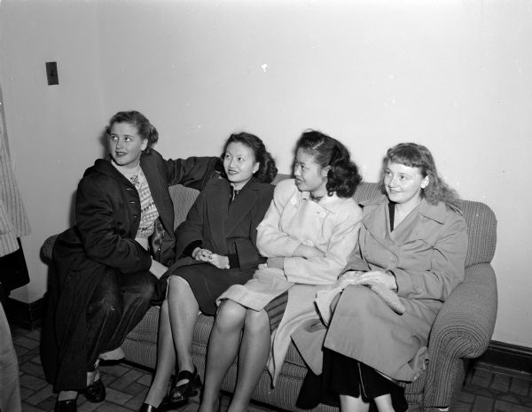 Four residents in the lobby of Ann Emery Hall, 623-71 Langdon Street, waiting for permission to return to their rooms after a fire. From left are Marilynn Mead, Willmette, Illinois; Lily Lee, Shanghai, China; May Ko, Hong Kong, China; and Ellen Anne Enright, Ashland.