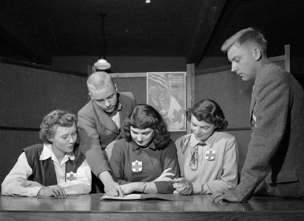 Organizers of the Junior Red Cross leadership training conference gather around a table. From left are: Lois Brustman, Wisconsin High School; Stefan Anderson, East High School; Sue Lentz, West High School; Barbara Ellis, East High School; and Lowell Lueptow, president of the Junior Red Cross High School Council.