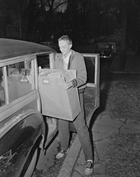 Bill Rayne, chairman of the motor corps division of the Junior Red Cross, unloads a box of cancer dressings for the Madison board of health during a Junior Red Cross leadership training event.