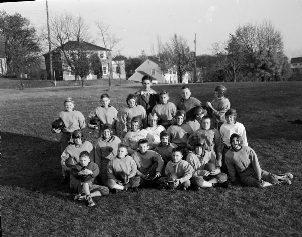 Group portrait of the Lakewood grade school football team and their coach following their loss to the Shorewood Hills grade school football team. Lakewood school in the village of  Maple Bluff,