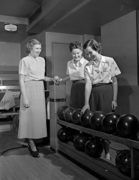 Pictured are three members of the bowling group of the Junior Division of the University League at the Wisconsin Union alleys.  From left to right are: Mrs. Jacob O. (Theodora J.) Bach, assistant program chairman of the Junior division; Mrs. Hazel L. Shands, secretary of the division; and Mrs. J. Riley Best, chairman of the bowlers. The Junior Division includes new women faculty members of the University of Wisconsin and the wives of new faculty members.