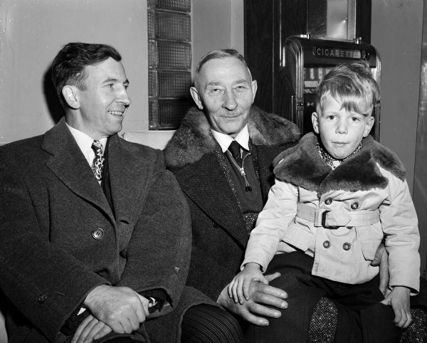John Eisen of Waterloo shown with his father, William (center), and his son, Carl, after his father arrived at Truax Field in Madison to visit his son and grandson.