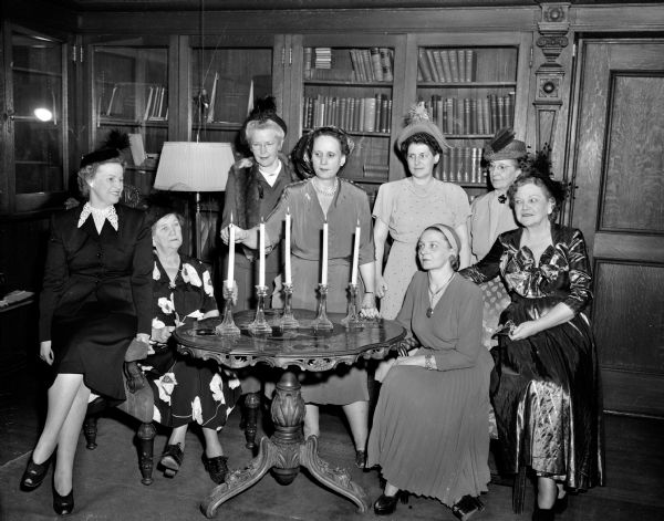 Group portrait of charter members of the Madison chapter of Zonta International, a classified service organization of executive and professional women, at a celebration of the 30th anniversary of the organization. Seated left to right are: Miss Marjorie Gile, Sgt. M. Pearl Saylor, Mrs. Marius (Erdis A.) Hansen, and Miss Winifred Layden.  Standing from left to right are: Mrs. Orrin (Lillian O.) Fried, Mrs. Jack Ferguson, Dr. Marvina Wilson, and Miss Lucile Clock.
