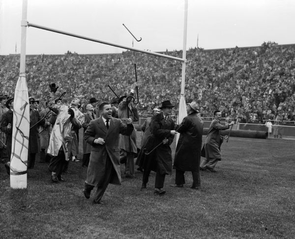 University of Wisconsin senior law students take part in the tradition of tossing their canes over the south goal post crossbar at Camp Randall stadium. The tradition says that if they catch their cane on the other side they will win their first case.
