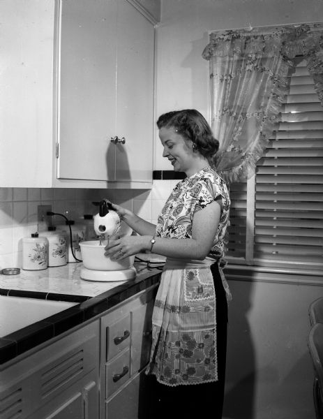 Doris Trameri is pictured in the kitchen of her new house at 568 Park Lane in Westmorland getting ready to celebrate her first wedding anniversary. She had to postpone her marriage for nearly a year and a half until she was released fron Lake View sanatarium as an "arrested case" of tuberculosis on June 15, 1948.
