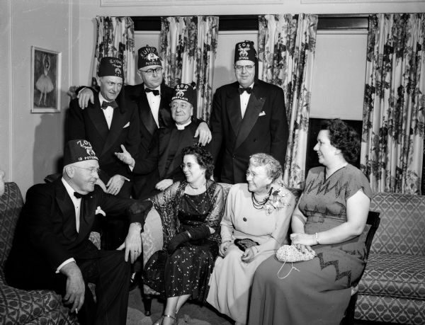 Some of the top Shrine officials who attended the Zor Shrine Potentate's Ball pose for a portrait at the Loraine Hotel. The men, left to right, are: Dr. M.E. Diemer, Tripoli Shrine in Milwaukee, imperial captain of the guards for the National Shrine; W.J. Klein, potentate of Zahrah Temple in Minneapolis; Reverand Howard A. LePere, Marshfield, Zor chaplain; and Otto Gelein, Eau Claire, chief rabban of Zor Temple. The women, left to right, are: Mrs. Klein, Mrs. Diemer, and Mrs. Gelein.