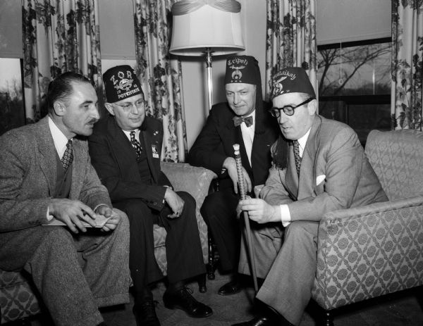 Imperial Potentate Harold Lloyd (right) talks with two fellow Shriners and a <i>Wisconsin State Journal</i> reporter during a press conference at the Loraine Hotel. From left are: reporter Sanford Goltz, Rufus F. Wells, Illustrious Potentate of Zor Shrine; and Thomas W. Melham of Tripoli Shrine in Milwaukee and an imperial captain of the guard.