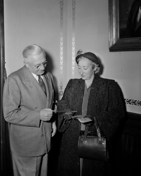 Gov. Oscar Rennebohm presenting a check for his contribution to the 1949 Madison Christmas Seal sale to Esther Hermsen of the Madison Tuberculosis Association.