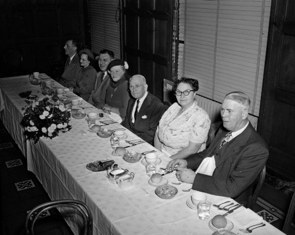 The guests of honor and special guests sit at a banquet table during the farewell dinner for Ole H. Johnson, retiring member of the State Board of Vocational and Adult Education Rehabilitation Division. Mr. Johnson is pictured to the extreme right. Also pictured, left to right, are:  Lloyd E. Berray, Mrs. Lloyd (Opal I.) Berray, C.L. Breiber, Mrs. William (Grace M.) Faulkes, William F. Faulkes, and Mrs. Ole (Jeannette) Johnson.