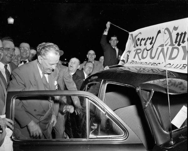 A crowd gathers around Roundy Coughlin, <i>Wisconsin State Journal</i> columnist, as he receives a new car from the Rounders' Club.