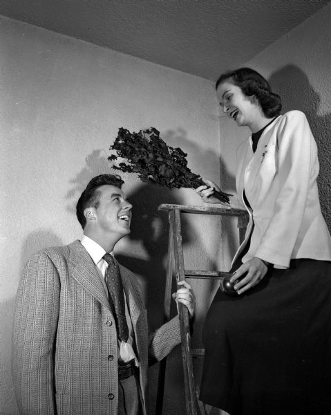 Robert O'Brien, general chairman, and Sheila Kivlin, chair of the buffet supper, prepare for the annual Christmas Subscription Dance for university students and young marrieds.