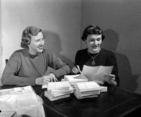 Preparing invitations for the Christmas Subscription Dance are Sue Weston, 166 Lakewood Boulevard, and Joan Ellis, 122 Lakewood Boulevard. The event is for university students and young marrieds.