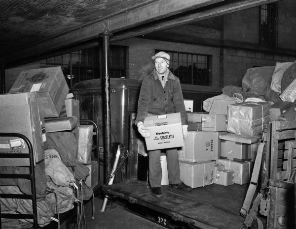 Henry Olson, a post office employee of nine years, was loading parcel post packages at the Madison post office this week, signalizing the start of the Christmas mailing rush.