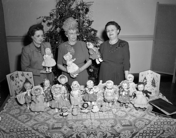 The social service department of the Madison Woman's Club display some of the dolls made for the children at the Children's Orthopedic hospital. From left to right are: Mrs. H.E. Witte, Mrs. H.J. Christ, and Mrs. William Remmel.