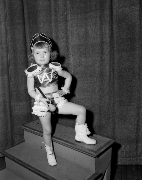 Ruth Ann Tilker, daughter of Mr. and Mrs. Fred W. Tilker of 106 Ohio Avenue, is an active 4-year-old baton twirler.  She started lessons with her brother Billy, age 10, and sister Nancy, age 9. She takes classes sponsored by the East Side Youth Activities Council at their recreation center, part of the Neighborhood Centers, a Red Feather service of the Community Chest.