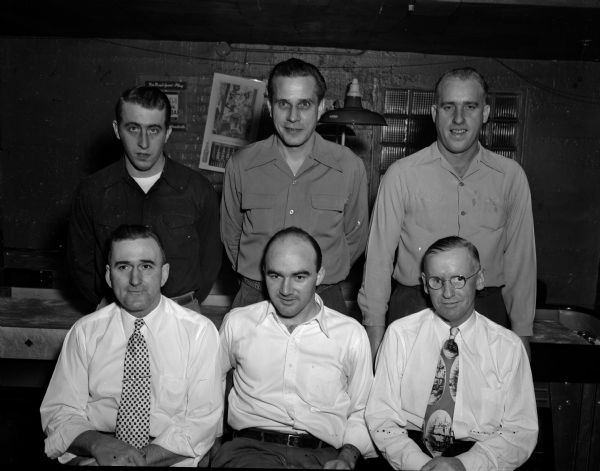 Twelve shuffleboard players (six men shown here), who took part in the tournament at the Breese Stevens Ball Park Tavern, 1 North Patterson Street.