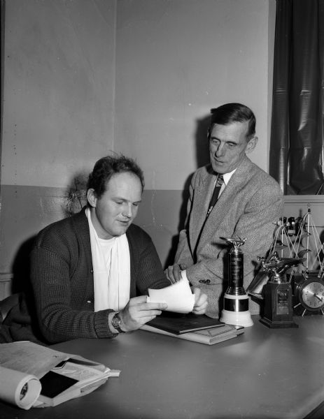 J. L. Griffith of 5208 Interlake Drive, Secretary and Treasurer of the Madison Outboard Club, and Roger Terry, president, plan for the upcoming racing season.  The club was formed in November of 1949.