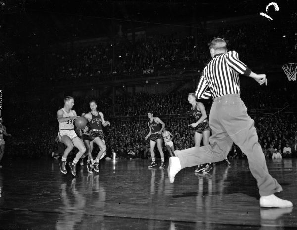 Wisconsin-Michigan basketball game, with unidentified players in uniforms with numbers.