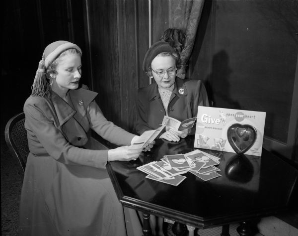 Mrs. Lindley V. (Virginia) Sprague and Mrs. George (Dorothy) Rentschler with the publicity materials they will use at information desks for the Madison Heart Fund drive.