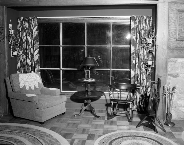 View of the living room of the residence of Mr. and Mrs. Bernard F. (Sylvia) Killian, 3814 Hillcrest Drive, including the large picture window framed by draperies with a leaf pattern in the colors of the room's decor: forest green, chartruese, cherry, and cocoa.