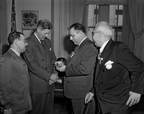 City Manager Charles Howell is shown receiving a "passkey to fun" from a representative of the St. Paulites Association, sponsors of the St. Paul Winter Carnival. Left to right: J.A. Bruno, City Manager Howell, William C. Davini, representative of the association who made the presentation, and A.R. Sanna.