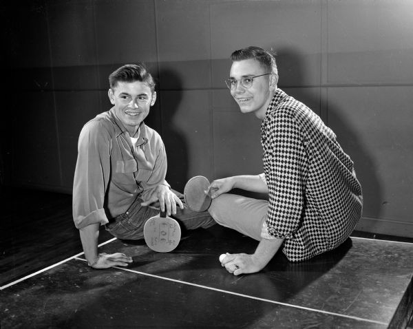 Bob Firehammer (left) and Bob Haukedahl sit on a ping pong table at the anniversary dance at the Loft Community Center, 16 East Doty Street.