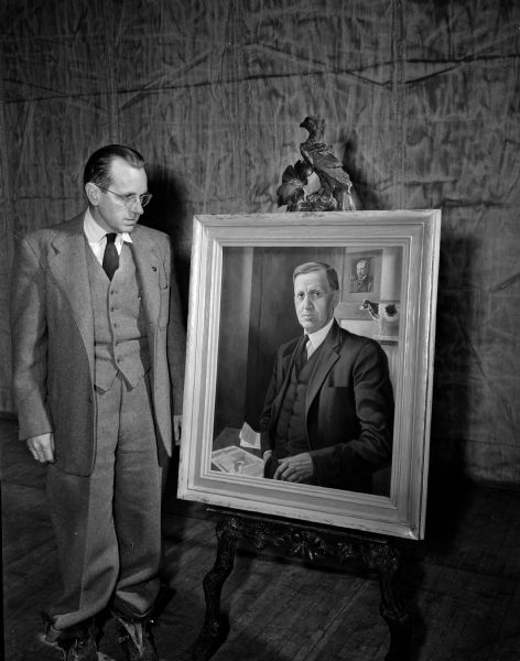 A portrait of A.J. Glover, a pioneer Wisconsin dairy leader, was presented to the University of Wisconsin college of agriculture. His son, W.H. Glover, is standing on the left next to the painting.