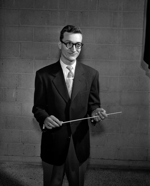 Portrait of Don Marcouiller, Madison parochial schools band director, holding a conducting baton.
