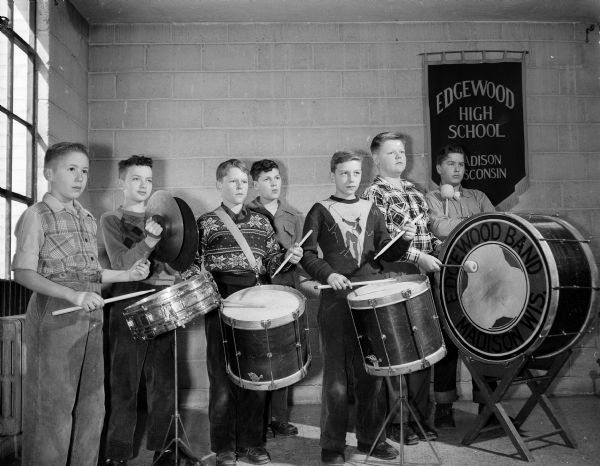 Seven boys in the percussion section of the Madison parochial schools band practice on drums and cymbals at Edgewood High School.