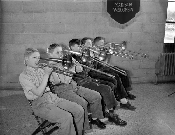 Five boys practice playing trombones in the Madison parochial schools band at Edgewood High School.