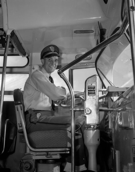 Portrait of Robert P. Garvey, a bus driver for the Madison Bus Company, seated behind the steering wheel.