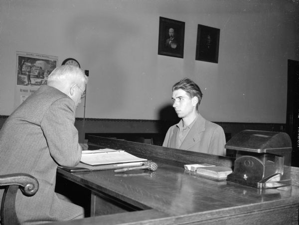 George Beecraft, 23, of 121 S. Marquette Street is shown (right) pleading not guilty before Superior Judge Roy H. Proctor to charges of safecracking at the John Deere Implement Co., 110 N. Thorton Avenue.