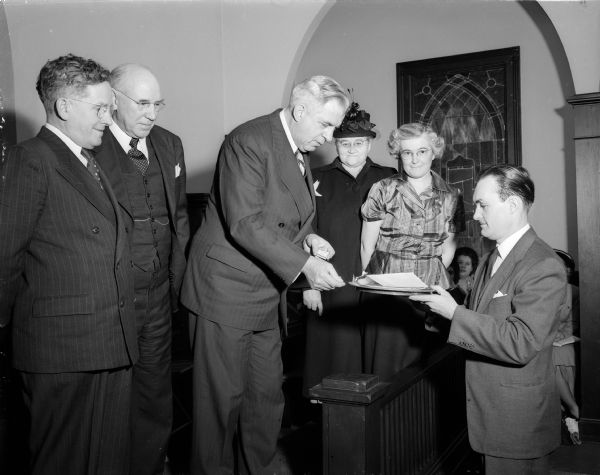 A mortgage burning ceremony was held at the South Shore Methodist Church, 610 Olin Avenue, and more than 100 persons participated. The church was built and founded as the People's Community Church in 1895.
Taking prominent parts in the rites were (left to right) the Reverend W. Ross Connor, district supervisor of the Methodist church; the Reverend A.D. Willett, pastor of the church; Bishop H. Clifford Northcott, Methodist bishop of Wisconsin; Mrs. E. Cunningham, representing the Women's Society of Christian Service (WSCS); Mrs. Rose Keppler, of the Ladies Sunday school guild; and Harold Hayes, representing the church trustees.