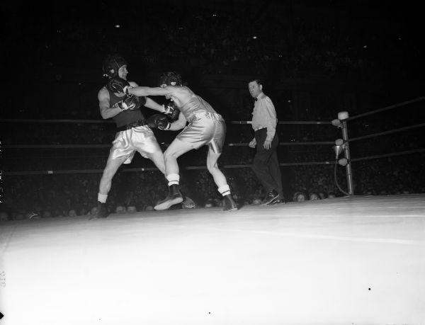 University of Wisconsin boxer Jimmy "Red" Sreenan, left, receives a  left-handed punch from University of Idaho boxer DeForest Tovey during a boxing match.